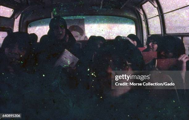 Interior view of a bus filled with Iranian female Basij members , wearing black chadors and holding pictures of the Ayatollah Khomeini, in Iran,...