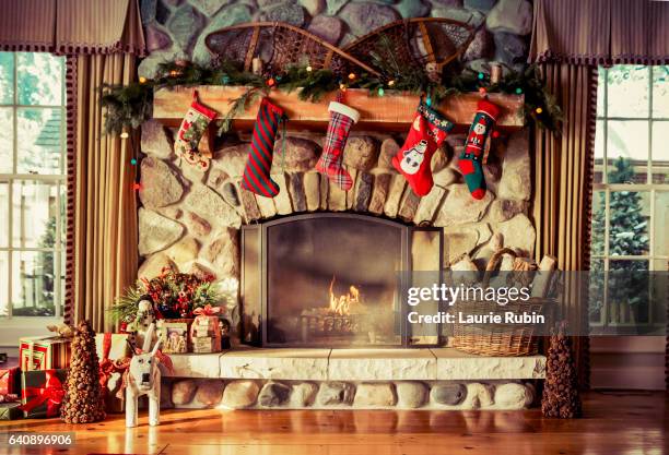 stone fireplace decorated for christmas - chimenea fotografías e imágenes de stock