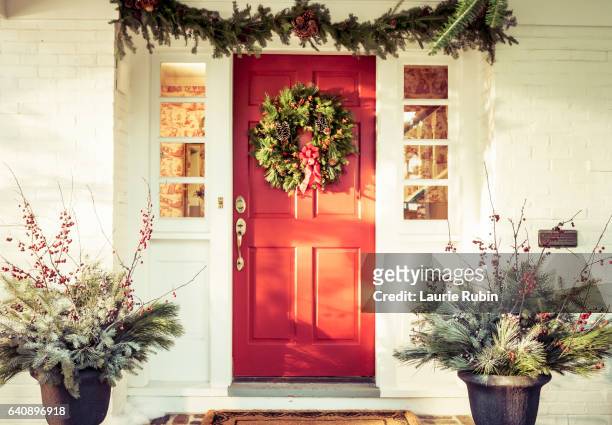 exterior red door decorated for christmas - corona di fiori composizione foto e immagini stock