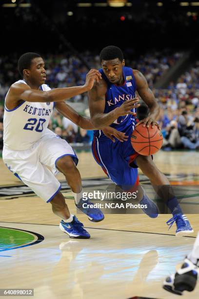 Guard Elijah Johnson from the University of Kansas drives to the basket past guard Doron Lamb from the University of Kentucky during the Championship...