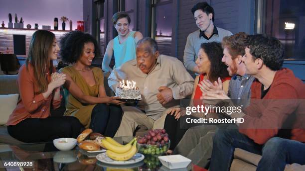 festa di compleanno per l'uomo afro-americano anziano - parents children blow candles asians foto e immagini stock