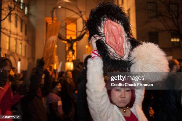 View of a demonstrator as she holds a model of a vagina over her head on Fifth Avenue , across from the statue of Atlas during the Women's March on...