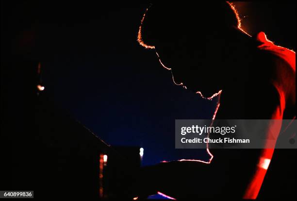 Silhouette of American Jazz musician McCoy Tyner plays piano as he performs during the New Orleans Jazz & Heritage Festival at the Fair Grounds Race...