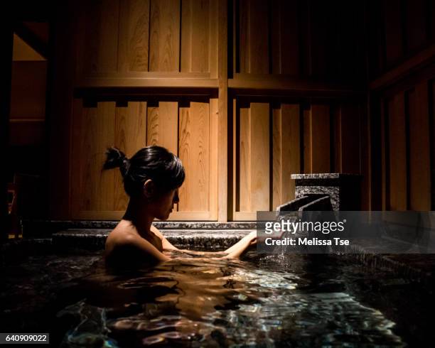 woman soaking in onsen (hot spring) - onsen japan stock pictures, royalty-free photos & images