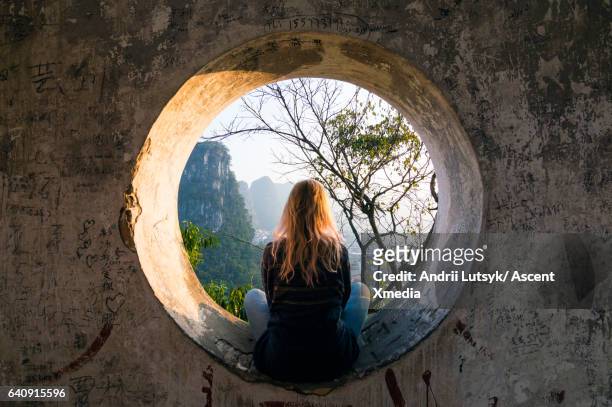 young woman enjoys view over yangshuo, karst mountains - evasión fotografías e imágenes de stock