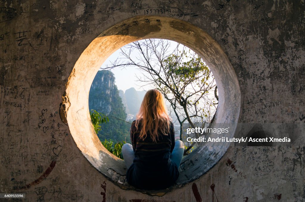 Young woman enjoys view over Yangshuo, karst mountains