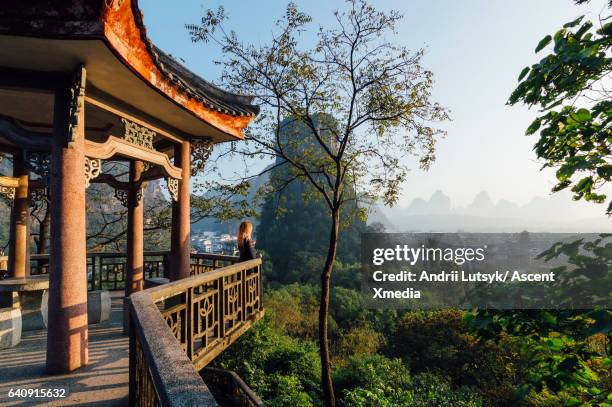 young woman enjoys view over yangshuo, karst mountains - guilin - fotografias e filmes do acervo