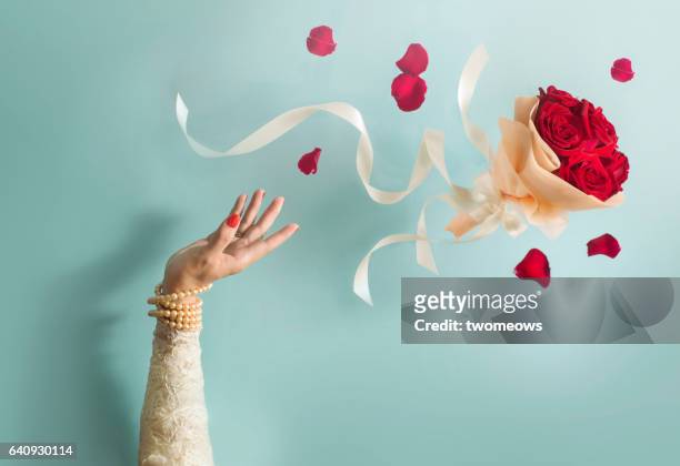 bride throwing bouquet in mid air. - bouquet stockfoto's en -beelden