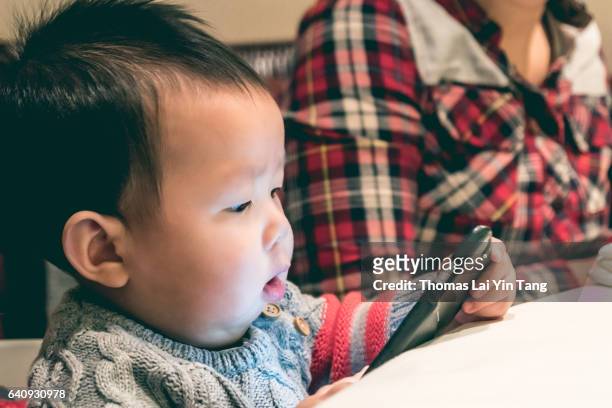 8 month old baby holding mobile phone for the first time. - my lai sit stock pictures, royalty-free photos & images