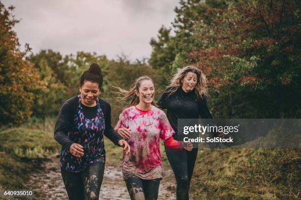 glückliche frauen laufen - mud stock-fotos und bilder