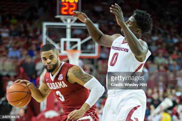Corban Collins of the Alabama Crimson Tide drives with the ball against Jaylen Barford of the Arkansas Razorbacks at Bud Walton Arena on February 1,...
