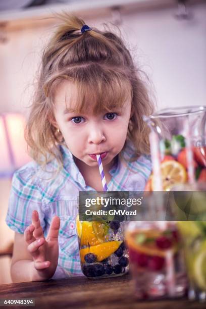 drinking infused water with fresh blueberries and oranges - infused water stock pictures, royalty-free photos & images
