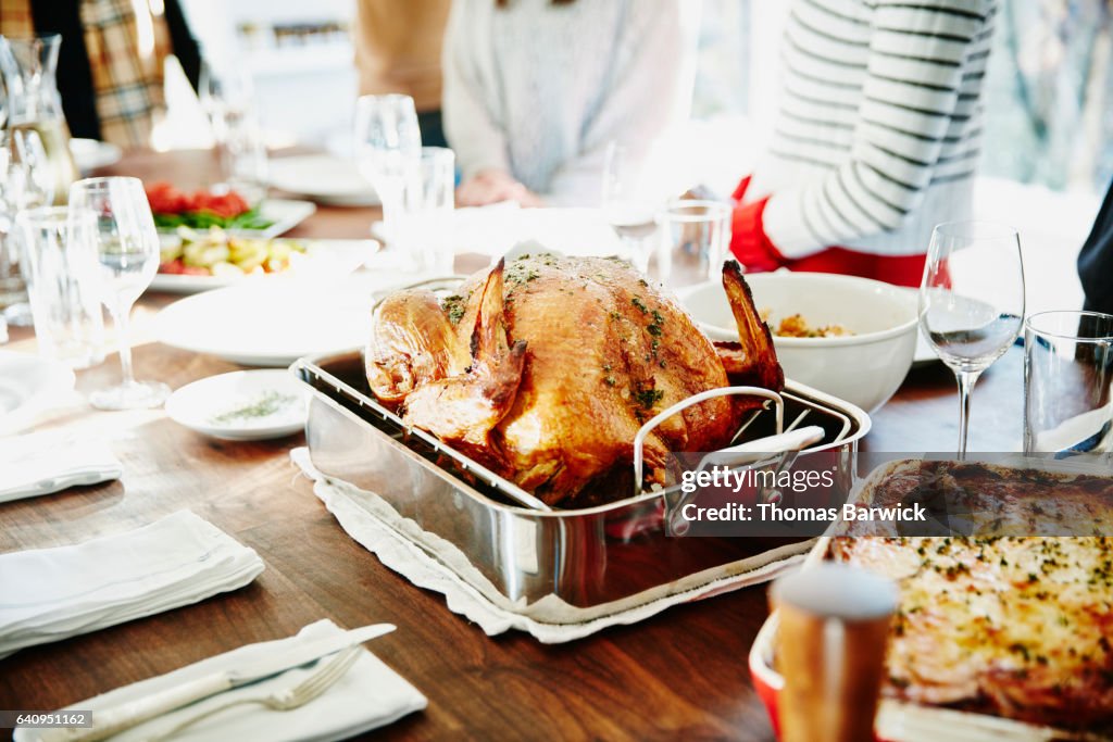 Turkey in roasting pan on table for holiday meal