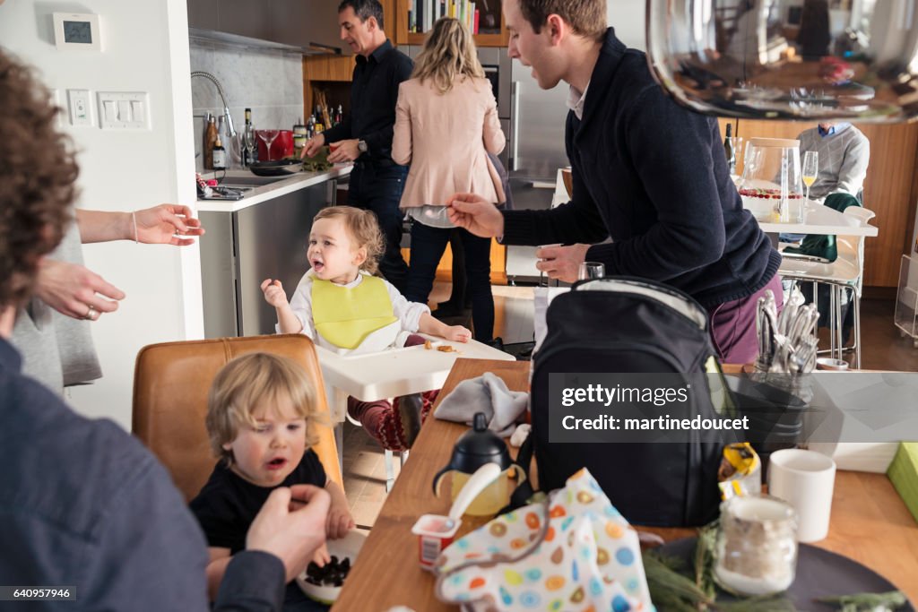 Väter, die Fütterung Kleinkinder vor großes Familienessen, jede Menge Action.