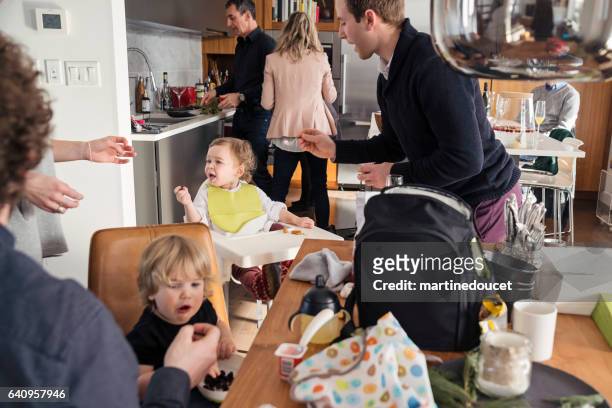 väter, die fütterung kleinkinder vor großes familienessen, jede menge action. - beengt stock-fotos und bilder