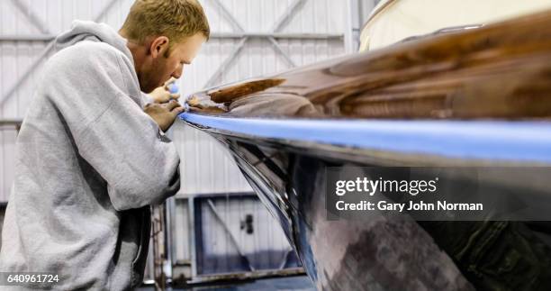 man working on boat in workshop - grey boot stock-fotos und bilder