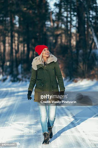 full length of happy woman walking on snow covered field - beautiful woman winter stock pictures, royalty-free photos & images