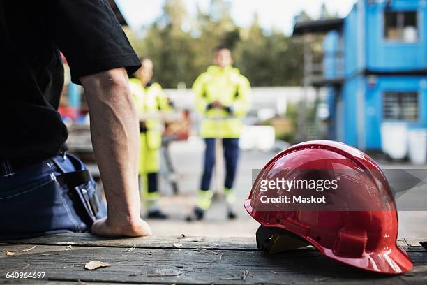 red hardhat by carpentry teacher leaning on table outdoors - reds training session stock pictures, royalty-free photos & images
