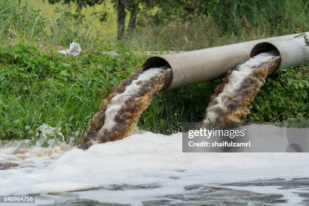 powerful water flowing from a large pipe using a water pump for agricultural use in paddy fields. - contaminación de aguas fotografías e imágenes de stock