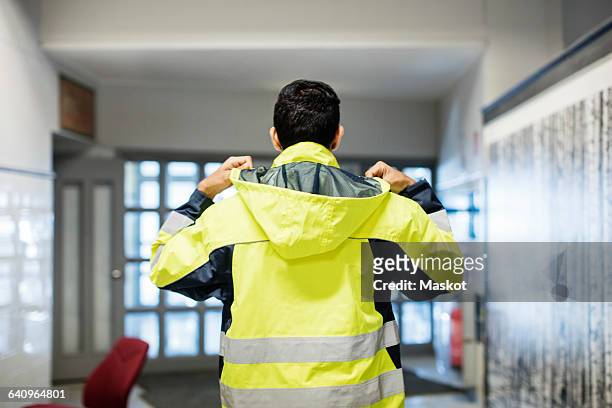 rear view of auto mechanic student wearing reflective jacket in workshop - jacket stock pictures, royalty-free photos & images