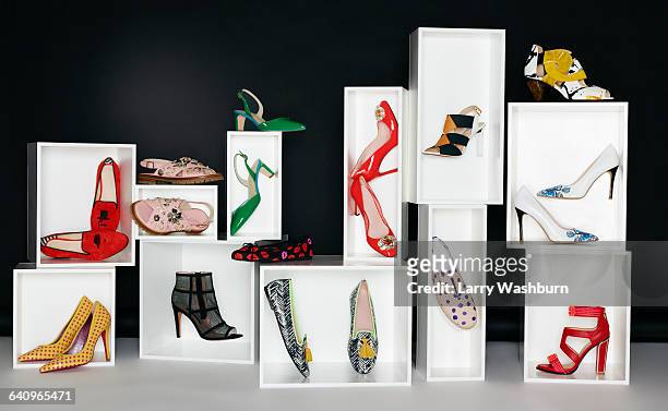 various pair of shoes in boxes arranged against black background - shoes box stock-fotos und bilder