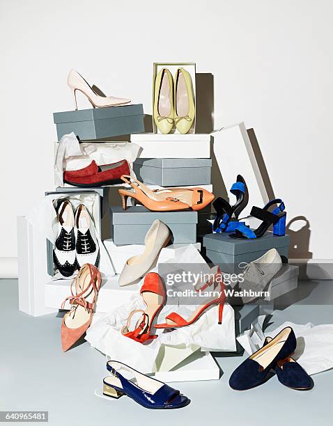 various pair of shoes with boxes against white background - schoenendoos stockfoto's en -beelden