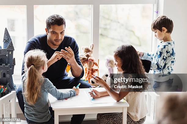 male teacher with students in preschool - nursery school building stock pictures, royalty-free photos & images