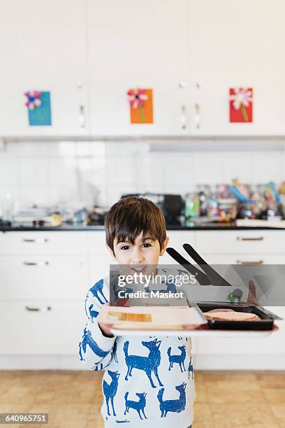 portrait of happy boy carrying food tray - peuterschool gebouw stockfoto's en -beelden