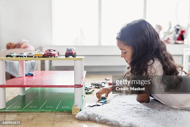 side view of girl playing with toy car in day care center - toy car stock pictures, royalty-free photos & images