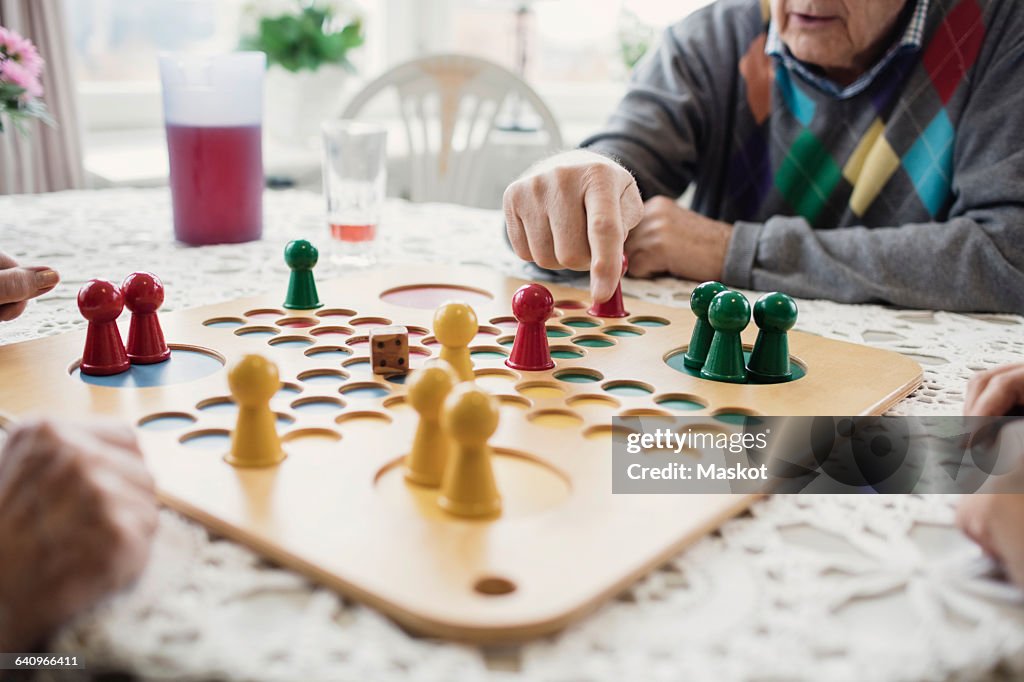 Cropped image of people playing Ludo in nursing home