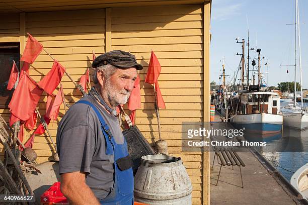 senior man standing at harbor by boats moored at lake - mecklenburg vorpommern - fotografias e filmes do acervo