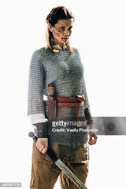 injured woman wearing chain mail holding sword against white background - chain mail stock pictures, royalty-free photos & images