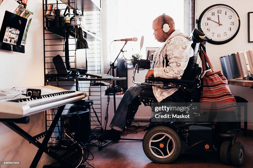 Side view of disabled musician with headphones in recording studio