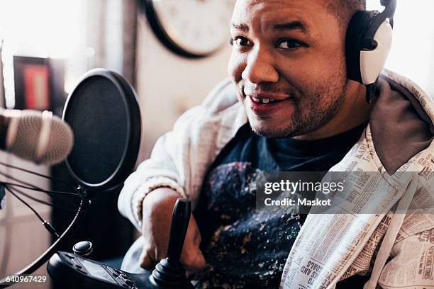 portrait of disabled musician with headphones in studio - motorized wheelchair stock pictures, royalty-free photos & images