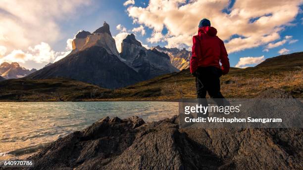 a man standing in front of cuerno principal with twilight sky - puerto natales stock pictures, royalty-free photos & images