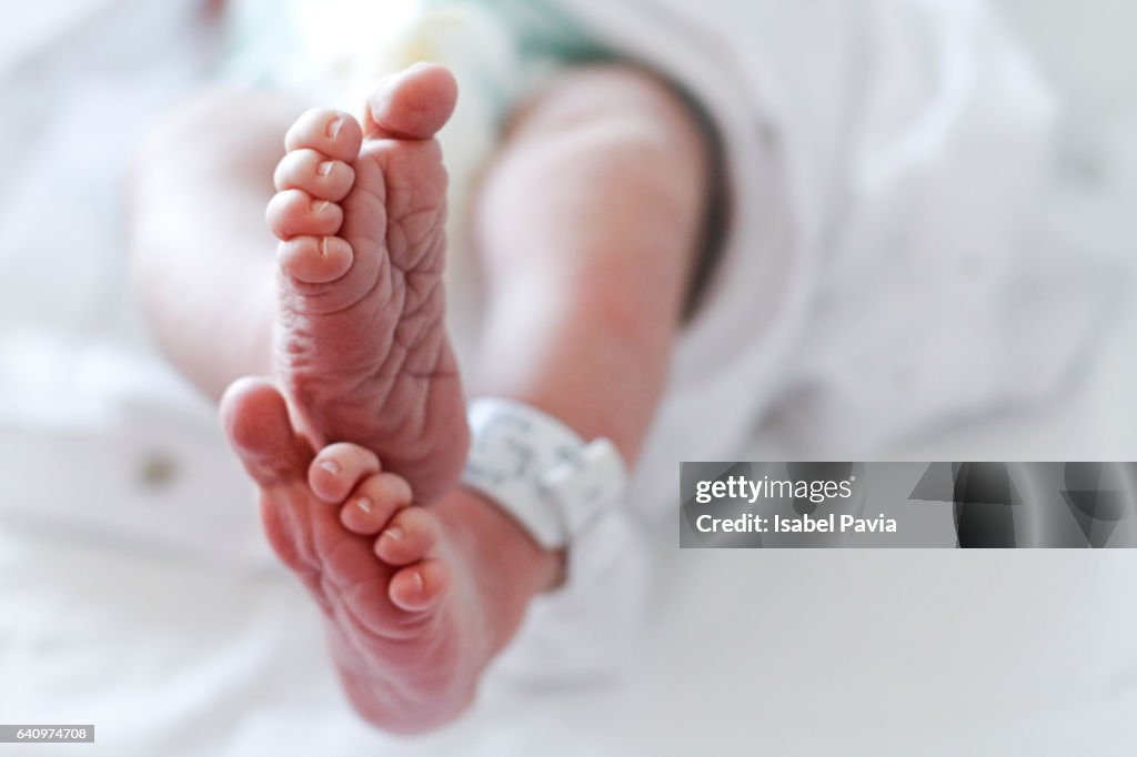 Newborn baby boy at hospital with identity tag on feet, close up