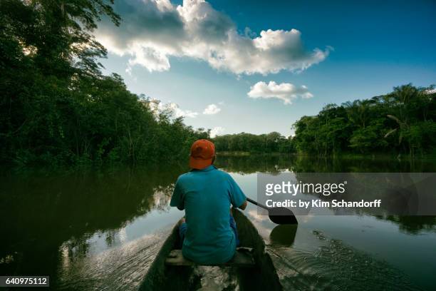 fishing in a small canoe on river maniti - amazonia fotografías e imágenes de stock