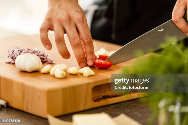 chef cutting cherry tomato on cutting board - cutting red onion stock pictures, royalty-free photos & images