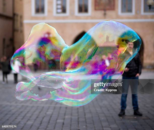 europe, czech republic, prague, view of person blowing giant soap bubbles "n - giants stock-fotos und bilder