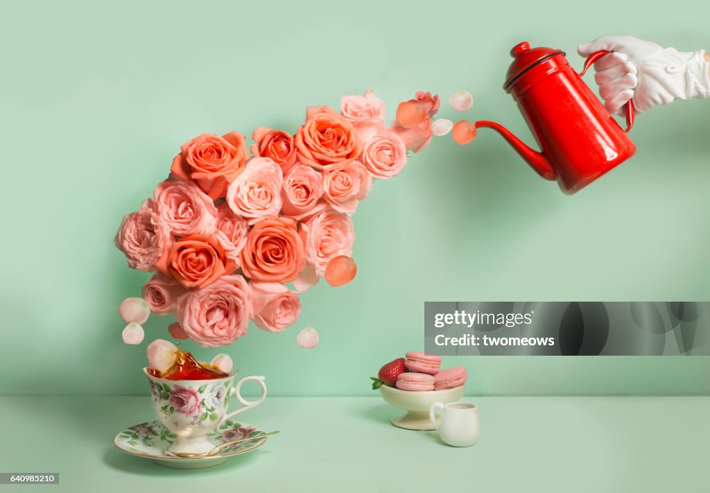 Buttler pouring a stream of roses into tea cup.