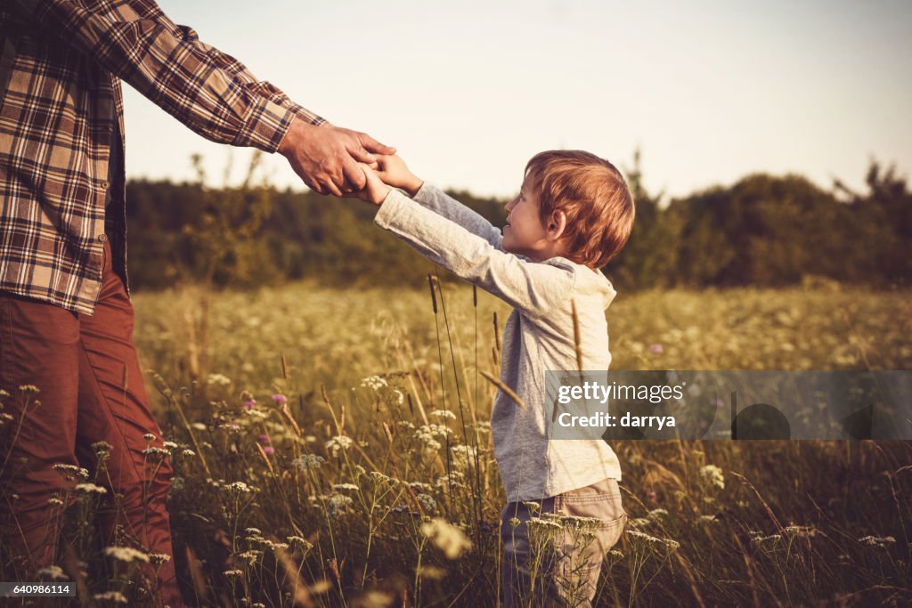 Father and son are playing on a field