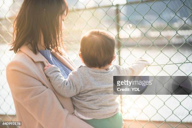 a baby and mother. - overcoat stock pictures, royalty-free photos & images