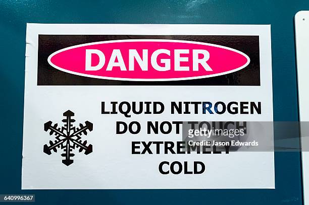 a sign warns of the dangers of liquid nitrogen and extreme cold in a science laboratory. - liquid nitrogen stock pictures, royalty-free photos & images
