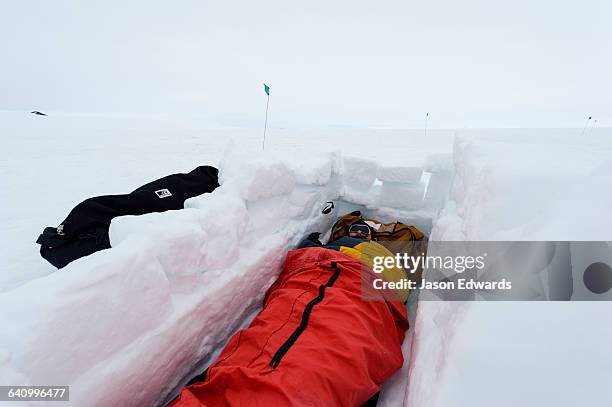 antarctic base staff in a sleeping bag in a sleeping pit in the sea ice carved from blocks of ice. - ross ice shelf stock pictures, royalty-free photos & images
