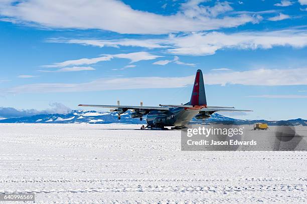 us air force hercules resting on skis on a sea ice tarmac. - herkules film 2014 stock-fotos und bilder