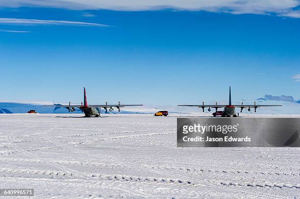 us air force hercules resting on skis on a sea ice tarmac. - herkules film 2014 stock-fotos und bilder