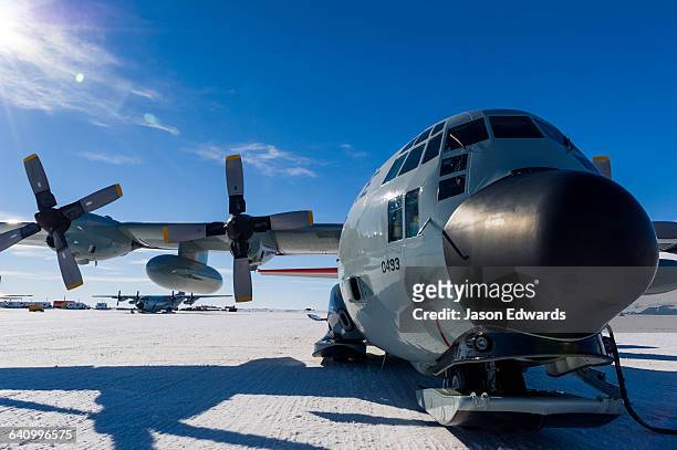 us air force hercules resting on skis on a sea ice tarmac. - hercules 2014 film stock-fotos und bilder