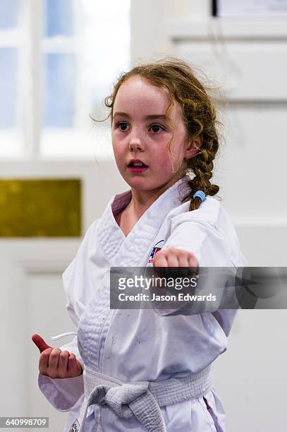 a girl throwing a punch during karate training. - girl martial arts stock pictures, royalty-free photos & images