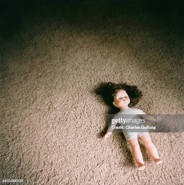 doll on carpeted floor - unheilschwanger stock-fotos und bilder