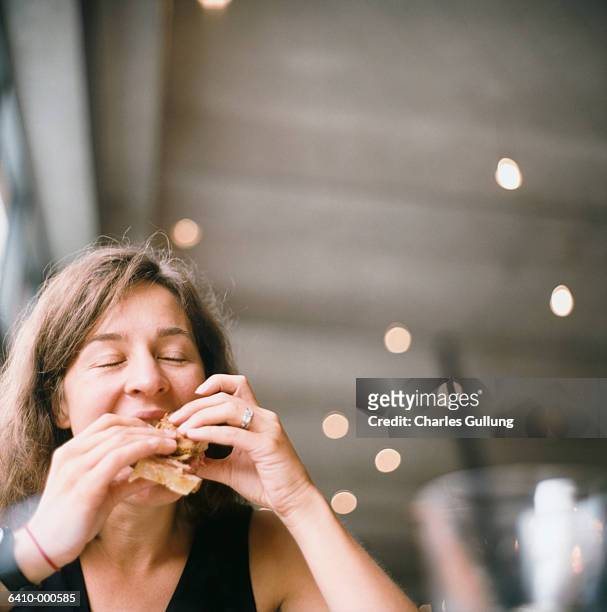 woman eating sandwich - eating sandwich stock-fotos und bilder